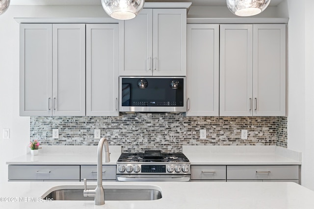212 Fawnwood St, Saint Johns, FL 32259 - kitchen featuring light countertops, stainless steel appliances, tasteful backsplash, a sink, and decorative light fixtures