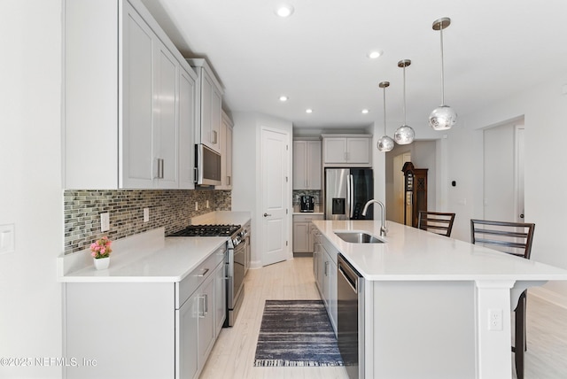 212 Fawnwood St, Saint Johns, FL 32259 - kitchen with light wood-style flooring, a center island with sink, tasteful backsplash, appliances with stainless steel finishes, and a sink