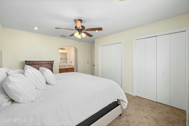 4133 Hidden Branch Dr N, Jacksonville, FL 32257 - carpeted bedroom featuring two closets, arched walkways, ceiling fan, visible vents, and ensuite bathroom