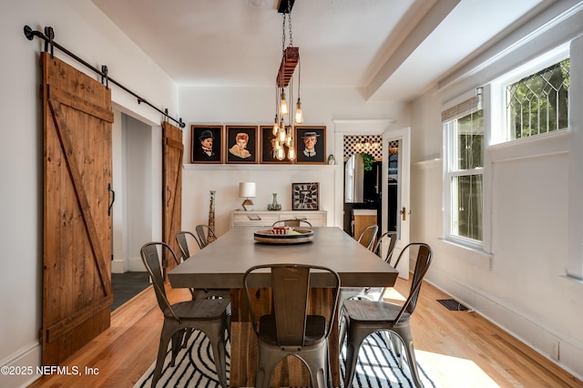 2855 Post St, Jacksonville, FL 32205 - dining room featuring baseboards, a barn door, visible vents, and light wood finished floors