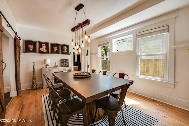 2855 Post St, Jacksonville, FL 32205 - dining area with baseboards, a barn door, and light wood finished floors
