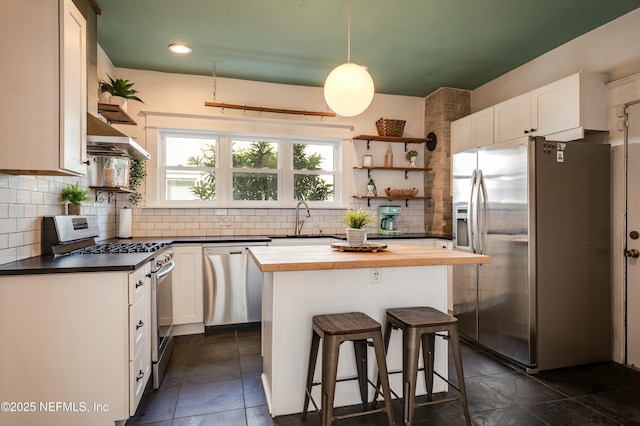 2855 Post St, Jacksonville, FL 32205 - kitchen featuring white cabinetry, open shelves, under cabinet range hood, wooden counters, and appliances with stainless steel finishes