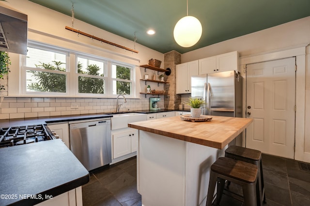 2855 Post St, Jacksonville, FL 32205 - kitchen featuring white cabinetry, backsplash, wooden counters, a sink, and appliances with stainless steel finishes