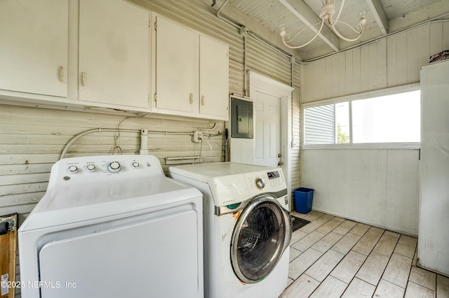 2855 Post St, Jacksonville, FL 32205 - clothes washing area with electric panel, wooden walls, wood finish floors, washing machine and dryer, and cabinet space