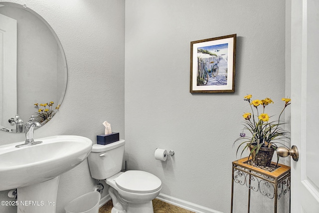 12424 Shady Bridge Trl, Jacksonville, FL 32258 - bathroom featuring a sink, a textured wall, toilet, and baseboards