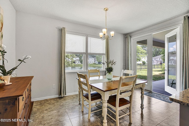 12424 Shady Bridge Trl, Jacksonville, FL 32258 - dining space with a chandelier, light tile patterned floors, a textured ceiling, and baseboards
