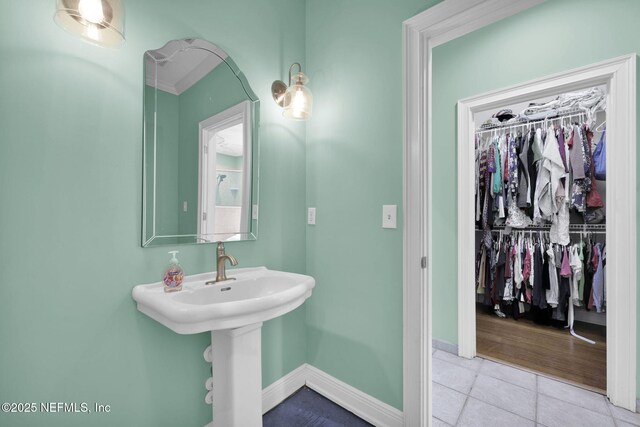 1365 Grosvenor Square Dr, Jacksonville, FL 32207 - bathroom with baseboards, a sink, tile patterned flooring, and a spacious closet