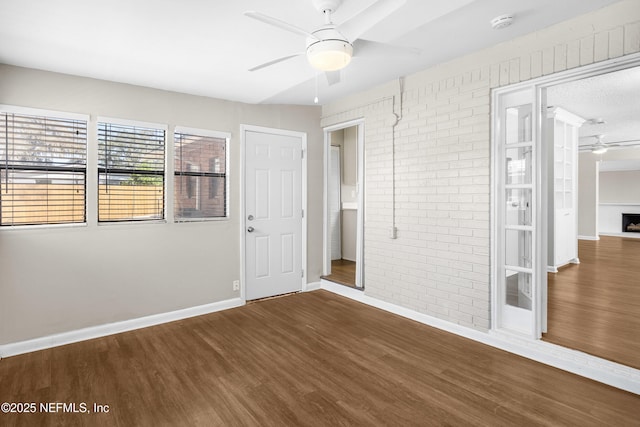 7653 Rolling Hills Dr, Jacksonville, FL 32221 - unfurnished bedroom with baseboards, brick wall, and wood finished floors