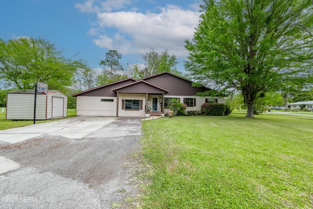 view of front of house featuring a front lawn, a shed, driveway, and an outdoor structure