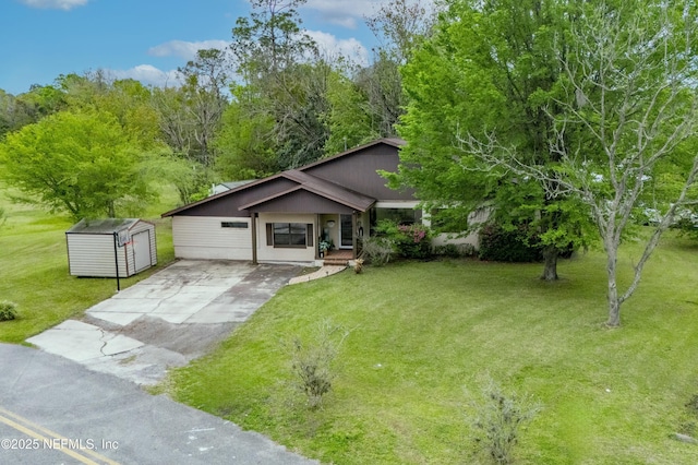 view of front of home featuring driveway, a front yard, and an outdoor structure