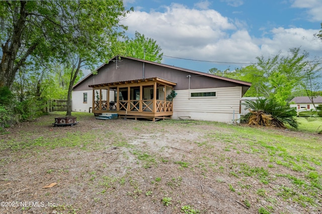 rear view of house with fence and a deck
