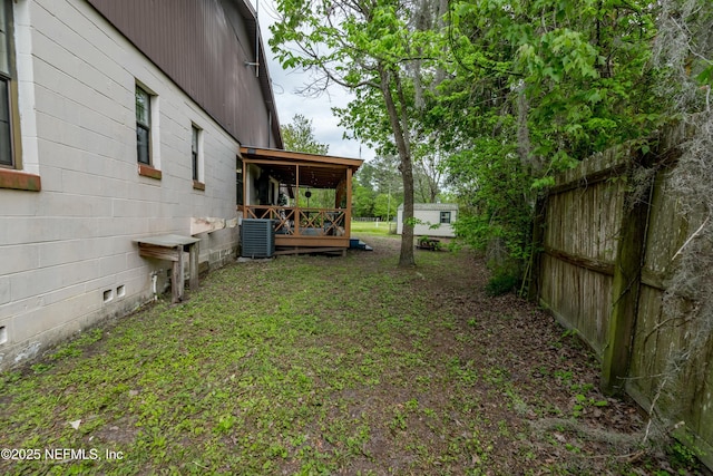 view of yard with fence and central AC unit