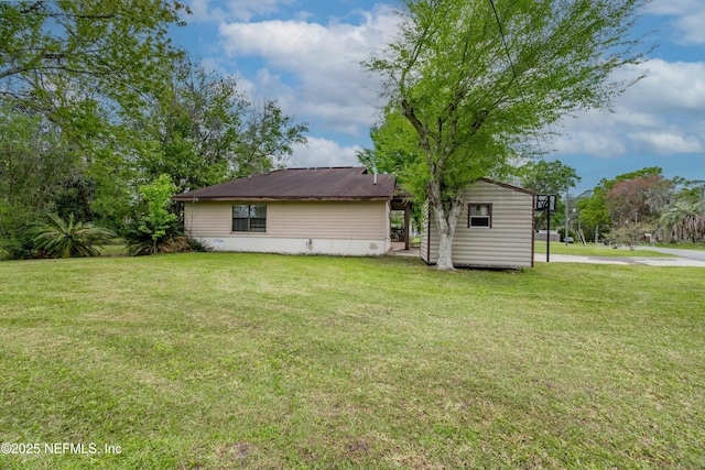 back of house with an outbuilding and a yard