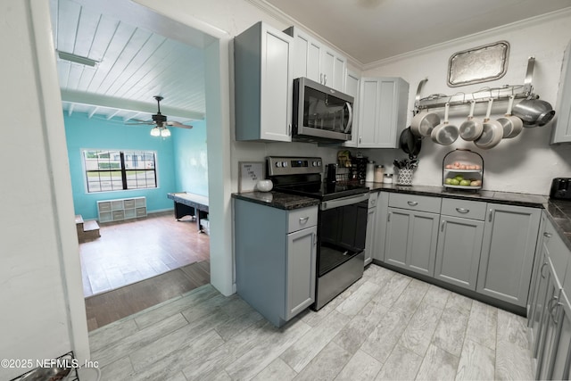 kitchen featuring ceiling fan, ornamental molding, stainless steel appliances, wood tiled floor, and gray cabinetry