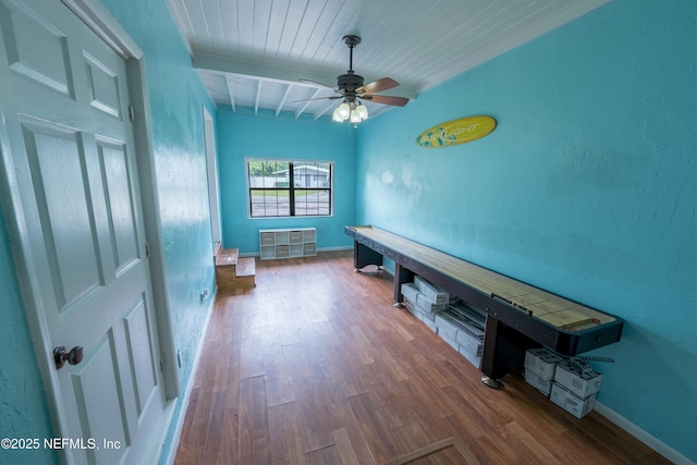 hall with baseboards, beamed ceiling, wood finished floors, and wooden ceiling