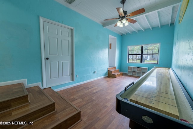 playroom featuring baseboards, wood finished floors, a ceiling fan, beam ceiling, and wooden ceiling