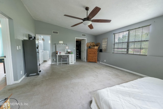 bedroom with baseboards, lofted ceiling, visible vents, and a walk in closet