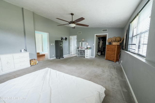 carpeted bedroom featuring visible vents, baseboards, a ceiling fan, lofted ceiling, and a spacious closet