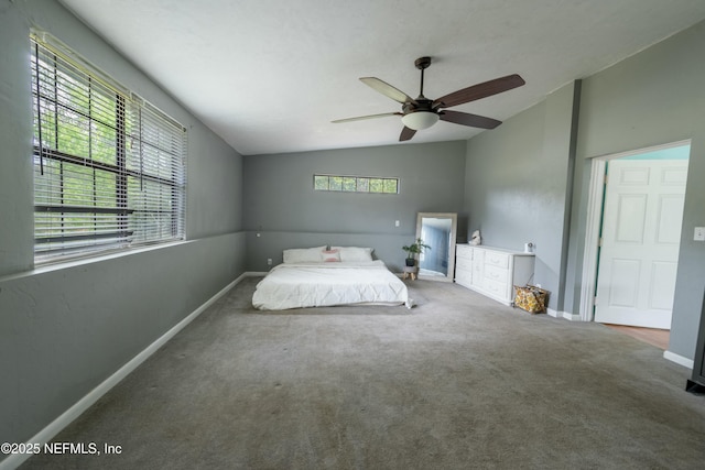 unfurnished bedroom featuring baseboards, carpet floors, lofted ceiling, and multiple windows