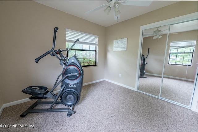 exercise area with baseboards, carpet flooring, and a ceiling fan