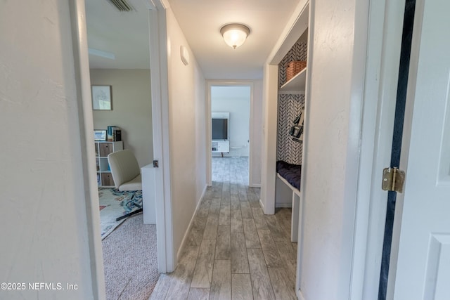 hallway featuring baseboards and light wood-style floors