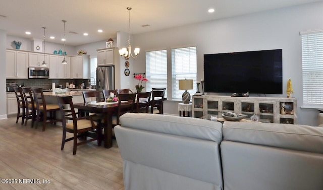 11466 Leatherback Ct, Jacksonville, FL 32256 - living area with light wood finished floors, recessed lighting, and an inviting chandelier