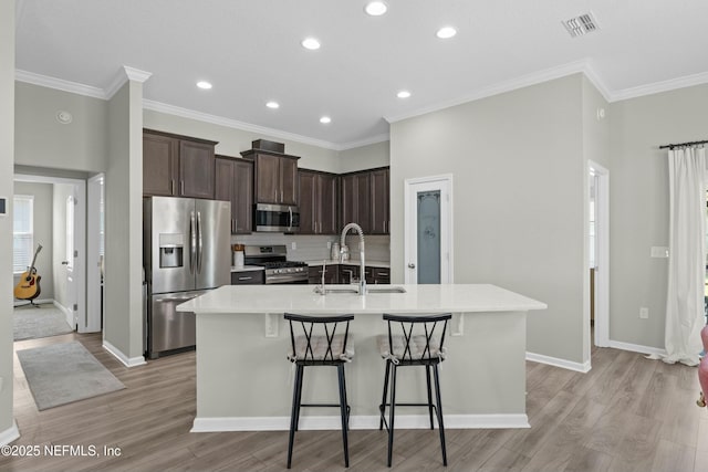 14 Balmoral Castle Dr, Saint Johns, FL 32259 - kitchen with a sink, appliances with stainless steel finishes, a kitchen breakfast bar, dark brown cabinets, and a center island with sink