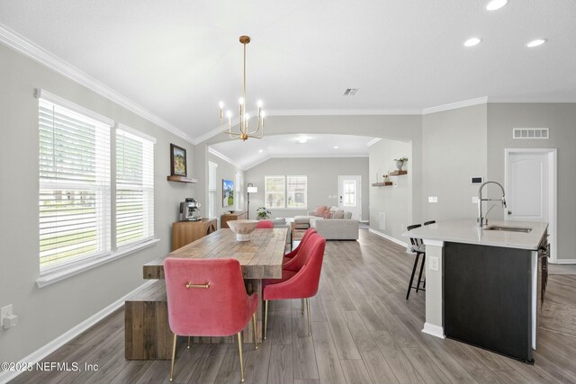 14 Balmoral Castle Dr, Saint Johns, FL 32259 - dining space with arched walkways, crown molding, vaulted ceiling, and light wood-style floors