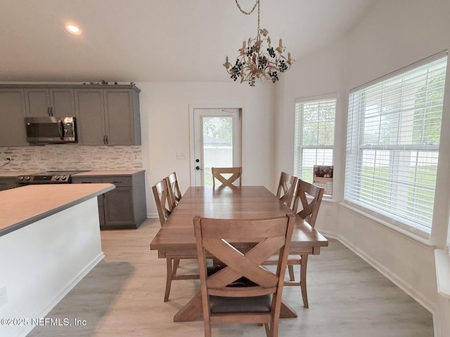 200 Nottingham Dr W, Saint Johns, FL 32259 - dining area featuring plenty of natural light, light wood finished floors, a chandelier, baseboards, and vaulted ceiling