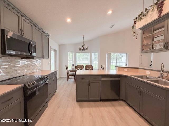 200 Nottingham Dr W, Saint Johns, FL 32259 - kitchen featuring stainless steel appliances, a sink, a chandelier, decorative backsplash, and light wood-style floors