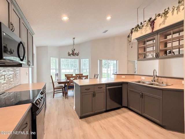 200 Nottingham Dr W, Saint Johns, FL 32259 - kitchen with stainless steel appliances, a sink, a peninsula, light wood-type flooring, and a chandelier