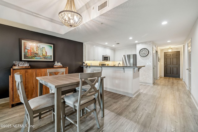1478 Riverplace Blvd Unit 1103, Jacksonville, FL 32207 - dining space with light wood finished floors, baseboards, visible vents, recessed lighting, and an inviting chandelier