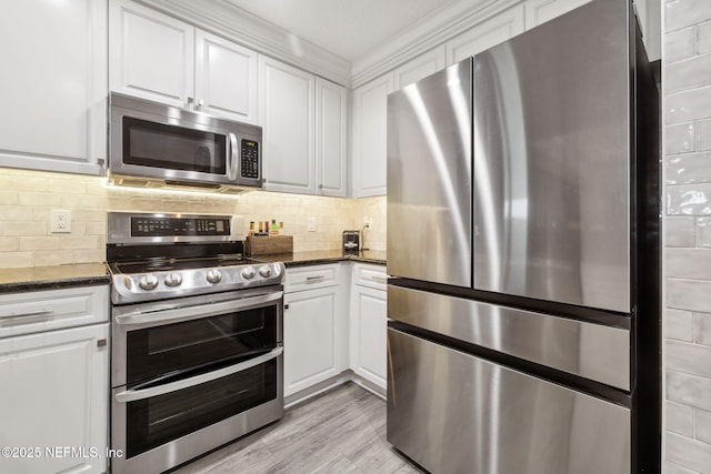 1478 Riverplace Blvd Unit 1103, Jacksonville, FL 32207 - kitchen featuring white cabinetry, tasteful backsplash, appliances with stainless steel finishes, and dark stone counters