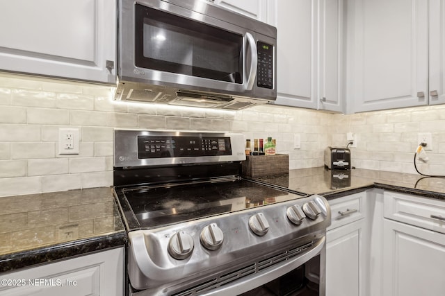 1478 Riverplace Blvd Unit 1103, Jacksonville, FL 32207 - kitchen with white cabinetry, stainless steel appliances, backsplash, and dark stone countertops