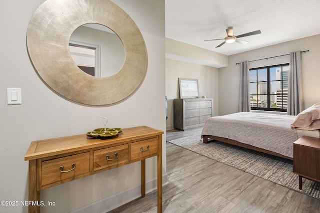 1478 Riverplace Blvd Unit 1103, Jacksonville, FL 32207 - bedroom with baseboards, light wood-type flooring, and ceiling fan