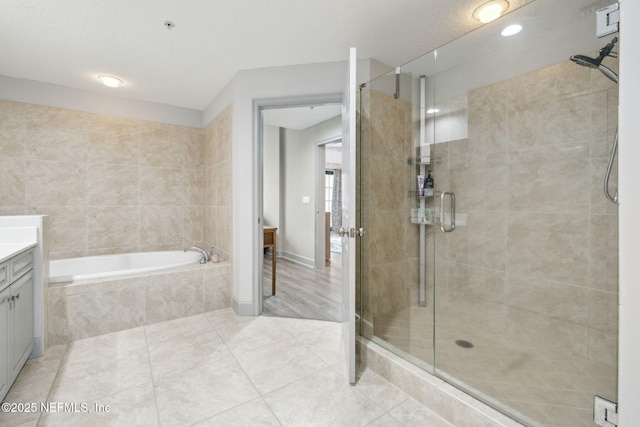 1478 Riverplace Blvd Unit 1103, Jacksonville, FL 32207 - bathroom with a bath, a stall shower, tile patterned floors, and vanity