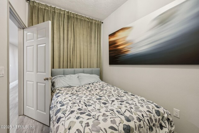 1478 Riverplace Blvd Unit 1103, Jacksonville, FL 32207 - bedroom featuring a textured ceiling and wood finished floors