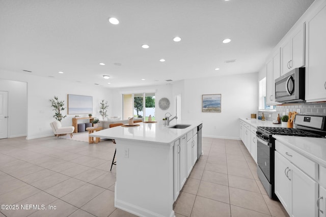 119 Cypress Banks Dr, Saint Johns, FL 32259 - kitchen featuring appliances with stainless steel finishes, a sink, recessed lighting, light tile patterned floors, and a kitchen bar
