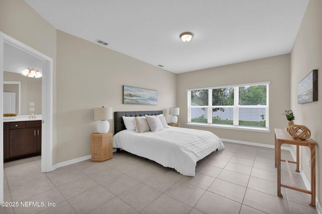 119 Cypress Banks Dr, Saint Johns, FL 32259 - bedroom featuring baseboards, light tile patterned floors, a sink, and ensuite bath
