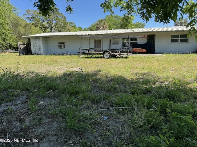 1103 Palm Cir, Jacksonville Beach, FL 32250 - rear view of property with a lawn, concrete block siding, and metal roof