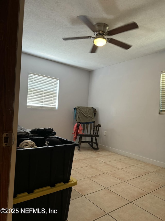1103 Palm Cir, Jacksonville Beach, FL 32250 - bedroom with light tile patterned flooring, a textured ceiling, a ceiling fan, and baseboards