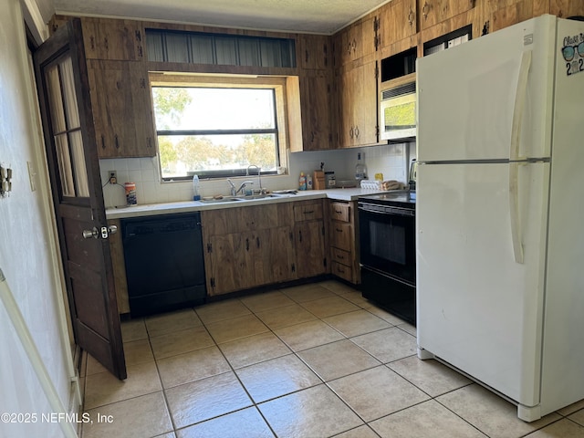 1103 Palm Cir, Jacksonville Beach, FL 32250 - kitchen featuring light countertops, light tile patterned floors, and black appliances