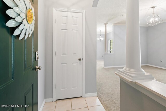 7800 Point Meadows Dr Unit 123, Jacksonville, FL 32256 - entrance foyer with decorative columns, an inviting chandelier, light tile patterned floors, and light carpet