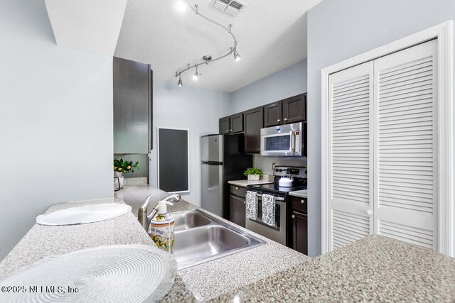 7800 Point Meadows Dr Unit 123, Jacksonville, FL 32256 - kitchen featuring light countertops, dark brown cabinetry, a sink, appliances with stainless steel finishes, and visible vents