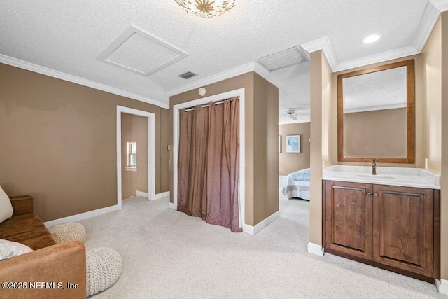 ensuite bathroom featuring ensuite bathroom, a textured ceiling, baseboards, ornamental molding, and a sink