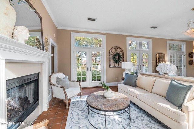 living room featuring crown molding, french doors, a fireplace, visible vents, and dark tile patterned flooring