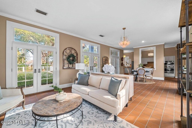 living area featuring visible vents, crown molding, tile patterned floors, an inviting chandelier, and french doors