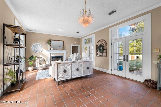interior space with visible vents, crown molding, french doors, and a fireplace