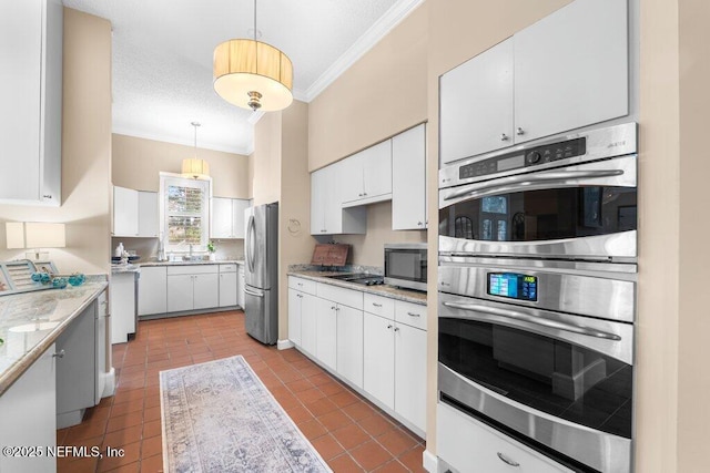 kitchen with white cabinets, crown molding, stainless steel appliances, decorative light fixtures, and tile patterned flooring