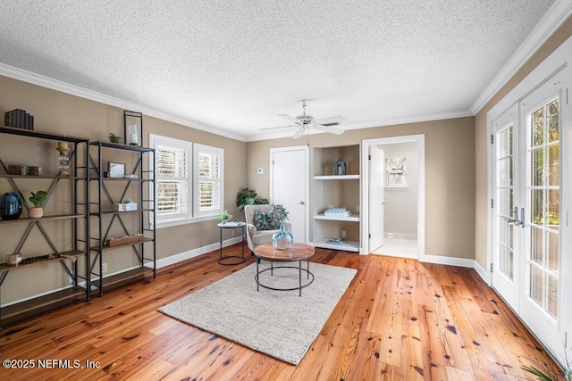sitting room with a textured ceiling, crown molding, and hardwood / wood-style flooring